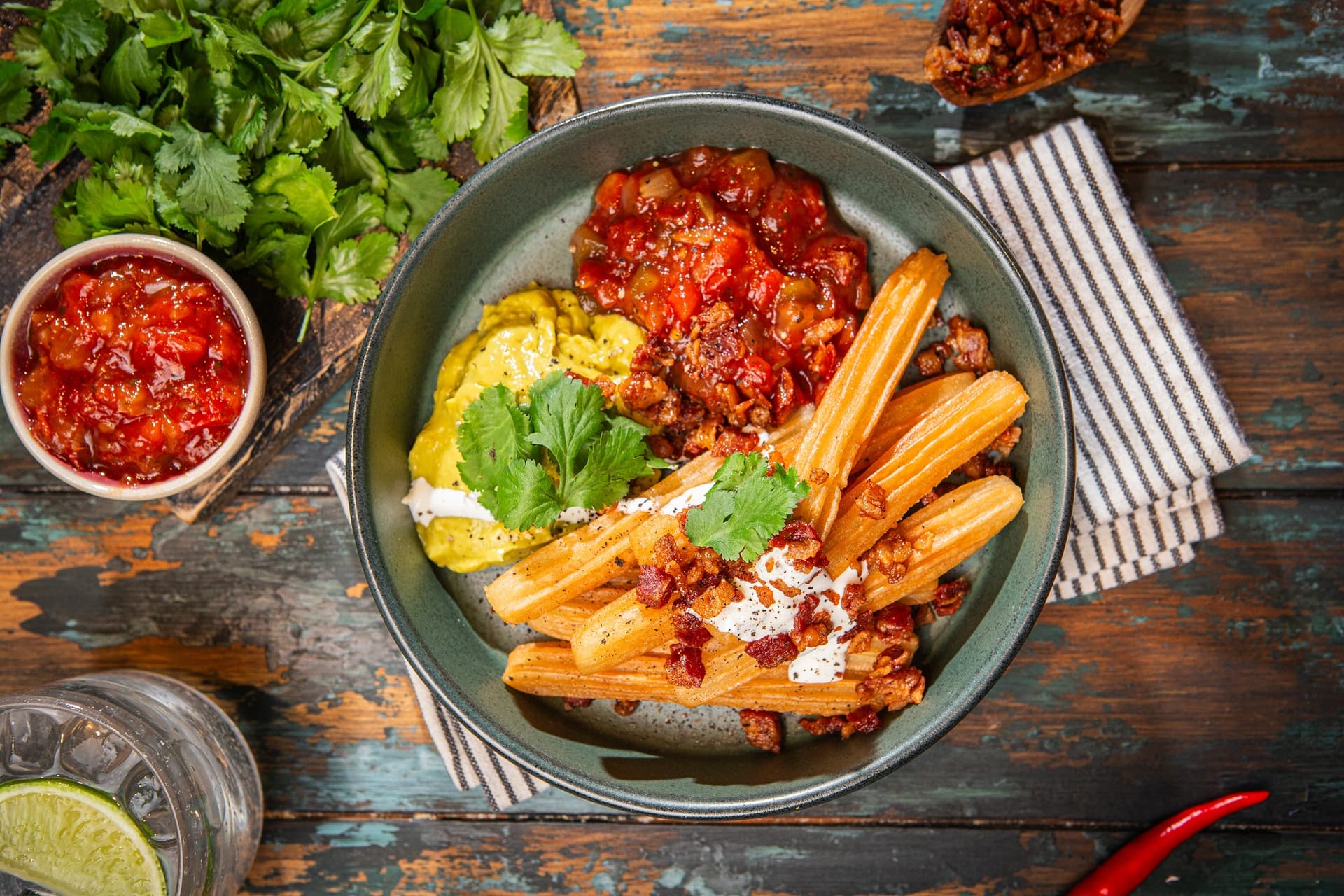 bowl z churros w stylu tex-mex z przepisu Aviko dla gastronomii, na stole w restauracji, obok miseczka z salsą pomidorową