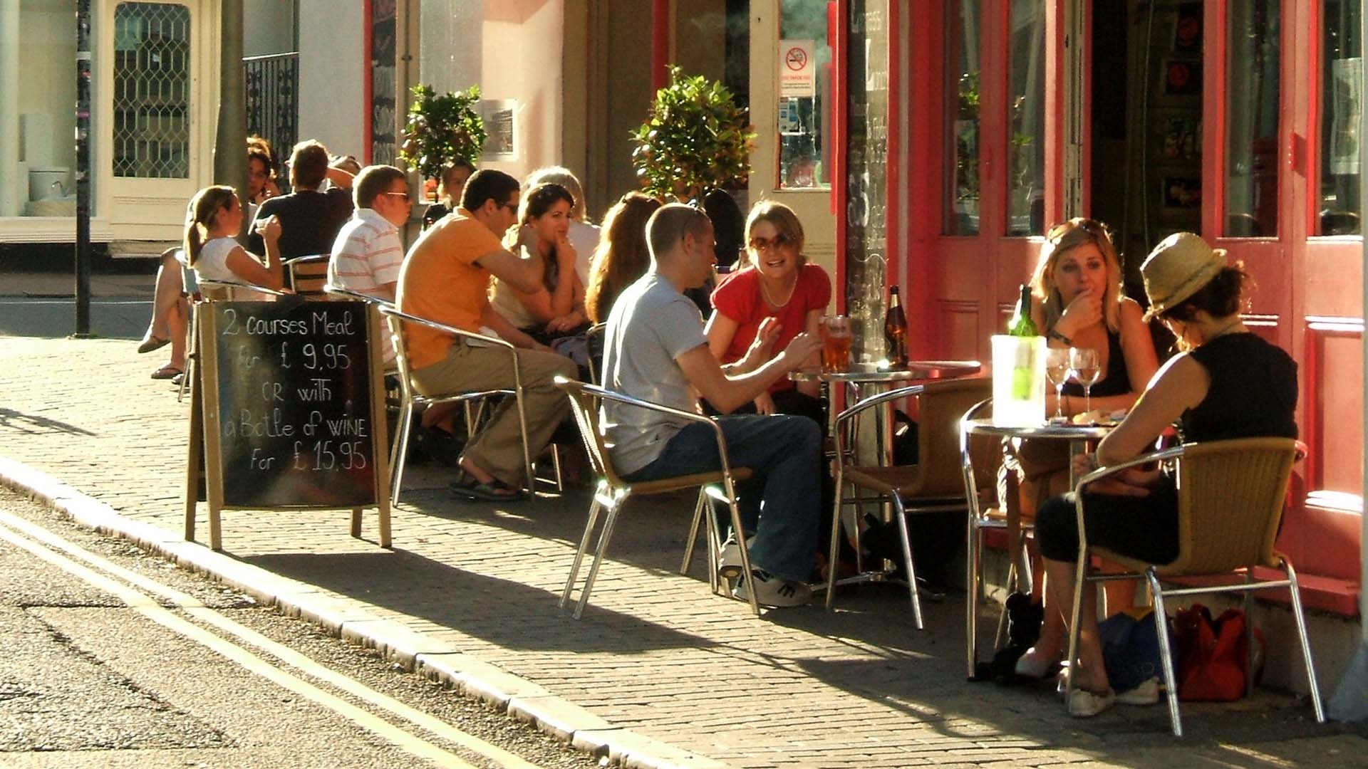 ludzie-jedza-przy-stolikach-na-zewnatrz-restauracji