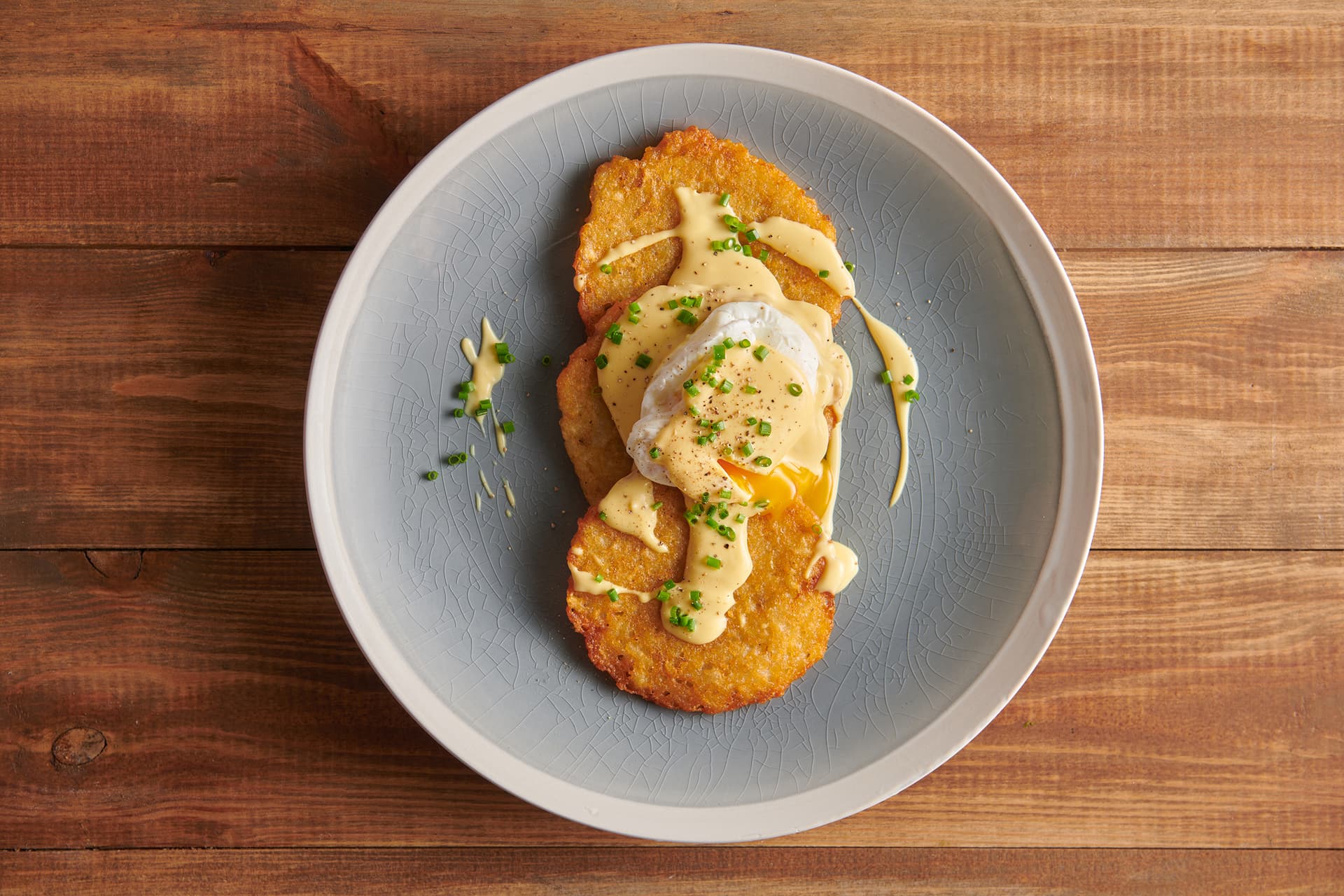 Placki ziemniaczane Aviko z jajkiem poszetowym, sosem holenderskim i szczypiorkiem