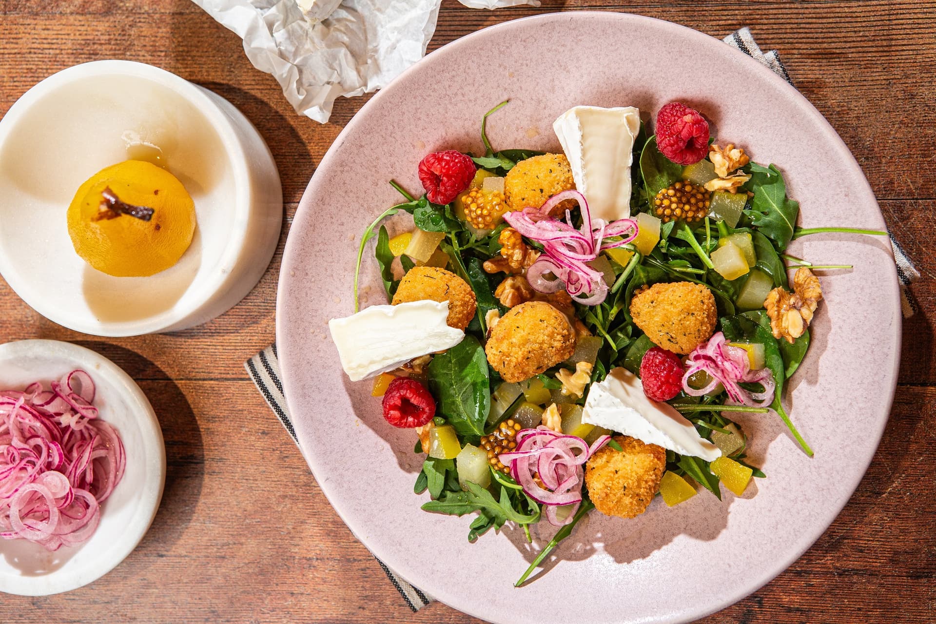 sałatka w restauracji, z serem camambert, przekąskami Aviko z serem camembert, rukolą, malinami i musztardą francuską